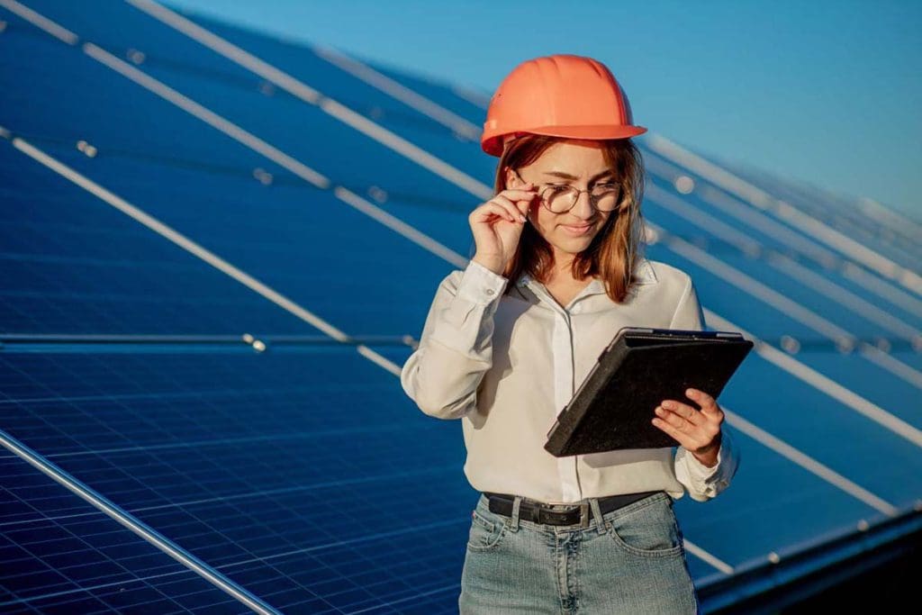 A technician examining solar panels on a rooftop by Hunter Valley