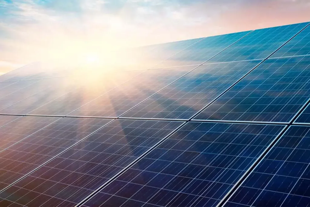 Solar panels with sun flare at sunrise or sunset.